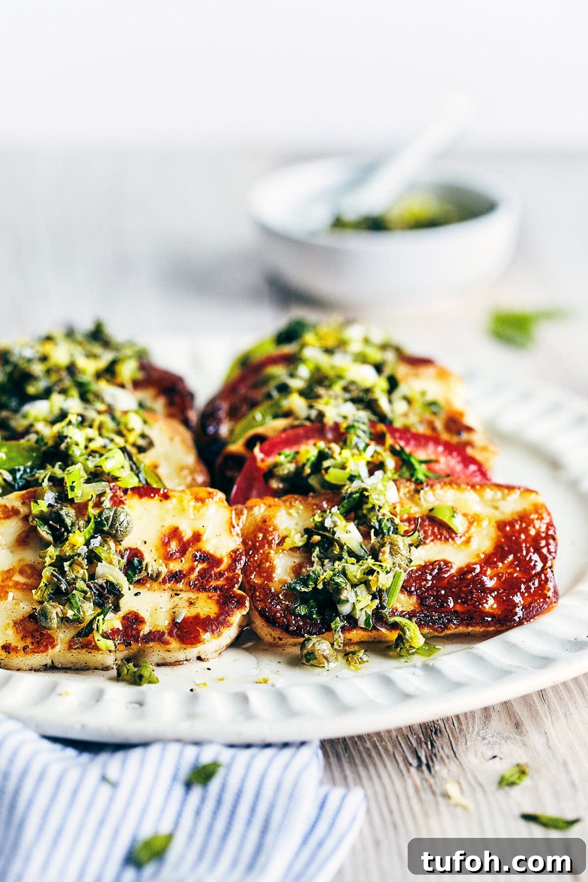 Grilled Halloumi and Tomato Salad with Fresh Herbs 11 Seared Halloumi with Tomatoes and a fresh herb topping on a plate.
