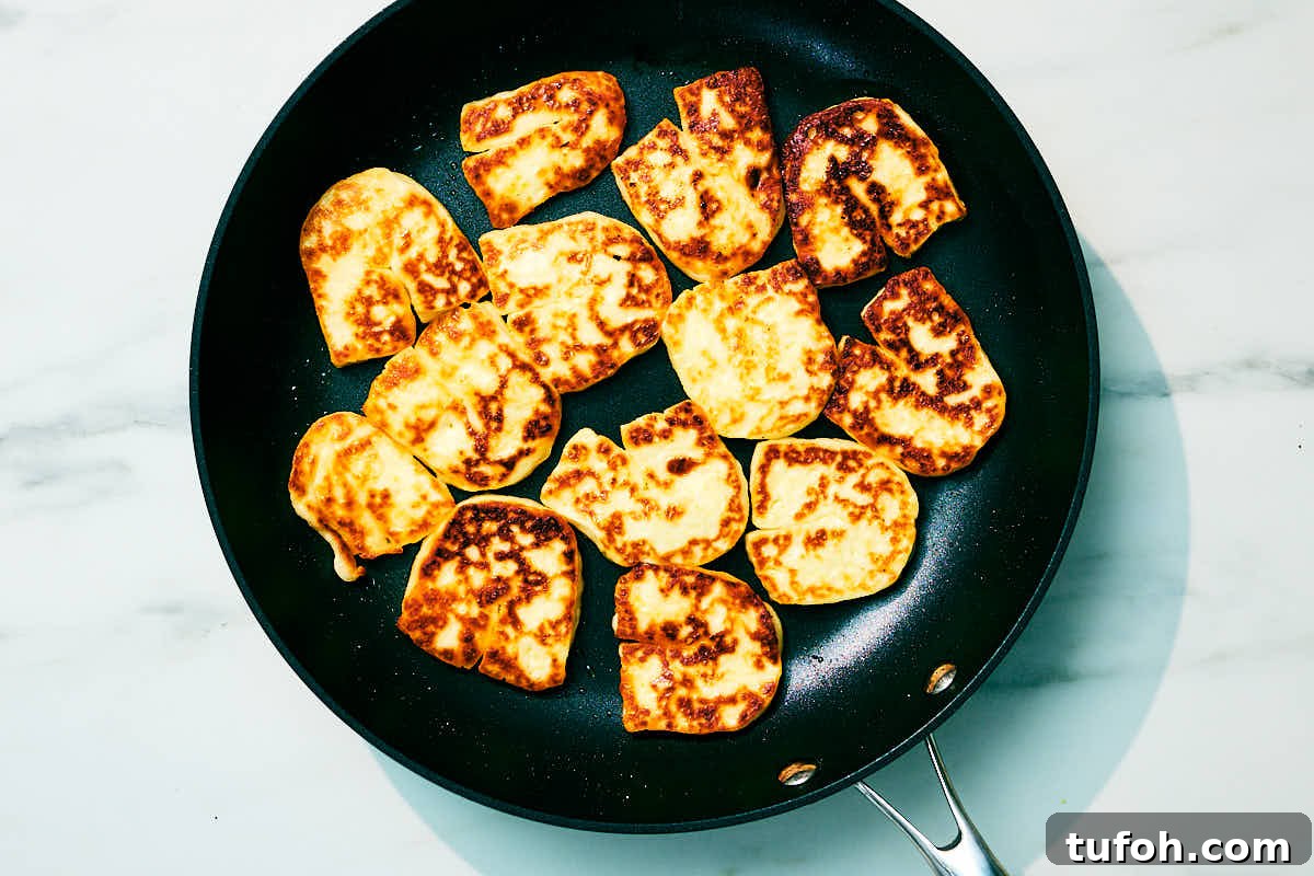 Grilled Halloumi and Tomato Salad with Fresh Herbs 8 Slices of halloumi cheese seared in a skillet.