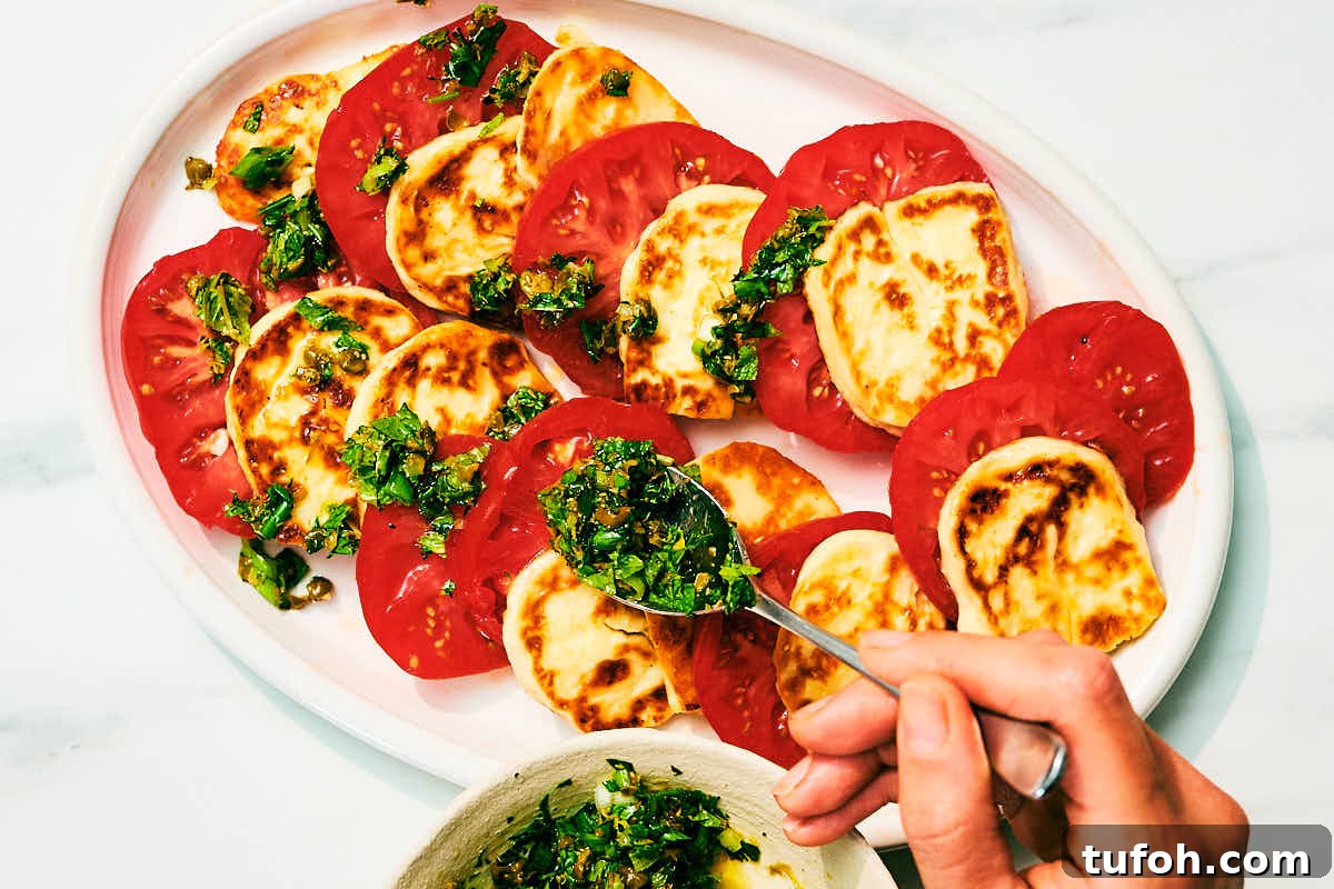 Grilled Halloumi and Tomato Salad with Fresh Herbs 10 Fresh herb topping being scattered over a Halloumi and Tomato Salad.