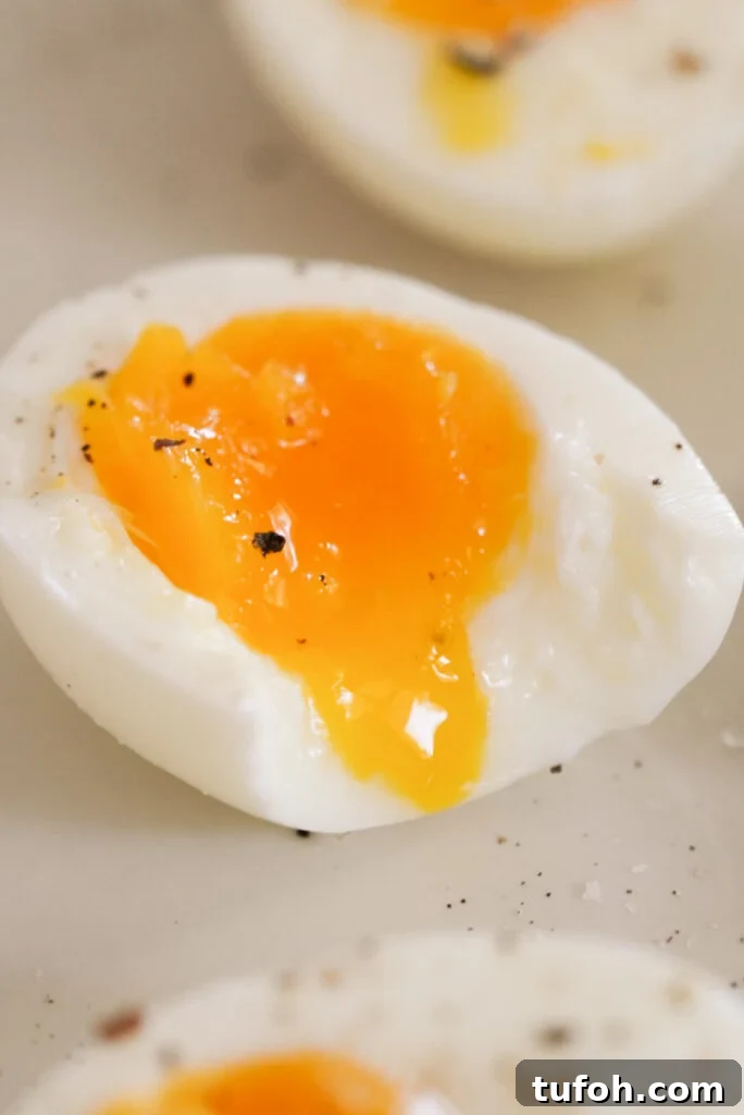 Perfect Jammy Eggs: Soft-Boiled Recipe for Runny Yolks 2 jammy egg with a bite taken out and the yolk oozing out