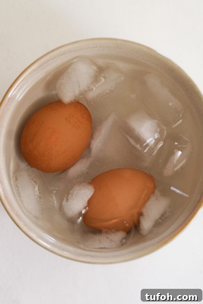 Perfect Jammy Eggs: Soft-Boiled Recipe for Runny Yolks 5 two boiled eggs in an ice bath