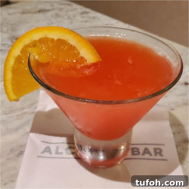 25+ Romantic Valentine's Day Cocktails and Toasting Drinks 3 Martini Seduction Cocktail with a orange wheel in a stemless martini glass