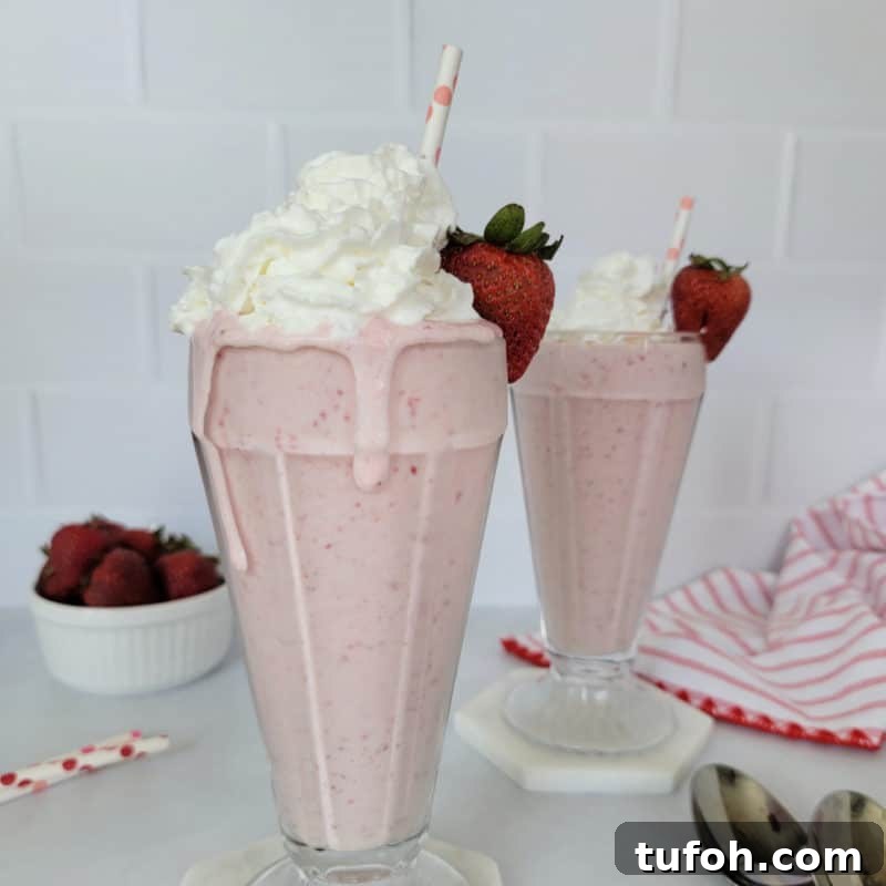 25+ Romantic Valentine's Day Cocktails and Toasting Drinks 24 Strawberry Milkshake garnished with whipped cream, a strawberry, and a paper straw