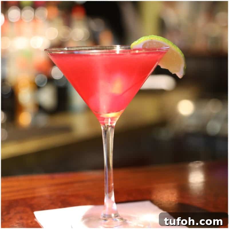 25+ Romantic Valentine's Day Cocktails and Toasting Drinks 6 Bright red martini with a lime wedge in a martini glass on a white napkin