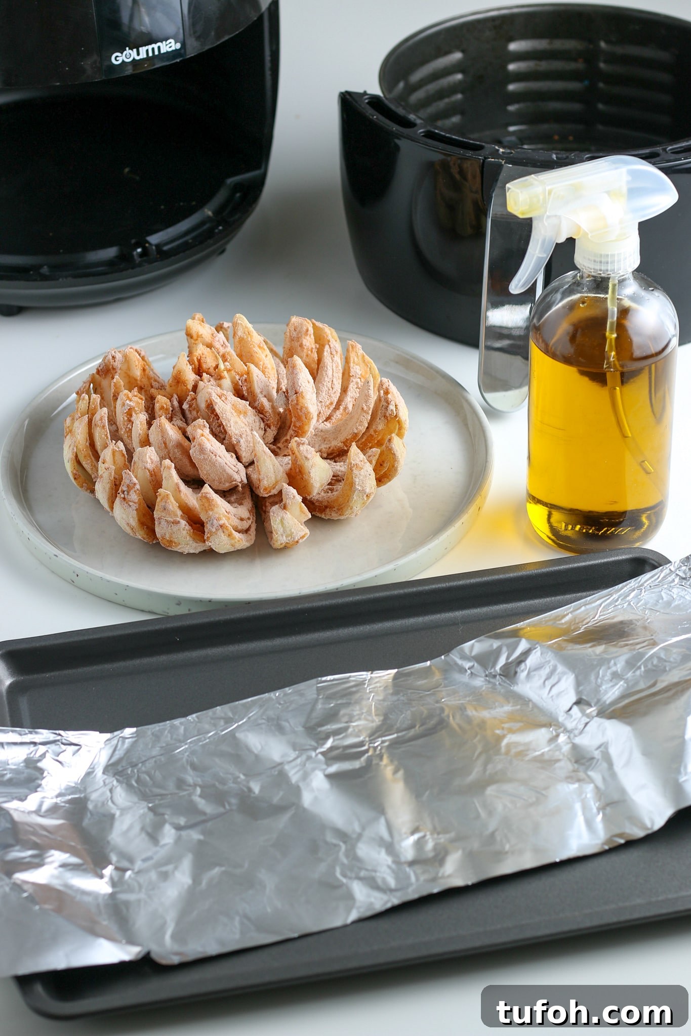 Crispy Air Fryer Bloomin' Onion Recipe for Game Day 11 the dredged onion sitting on a plate in front of an air fryer