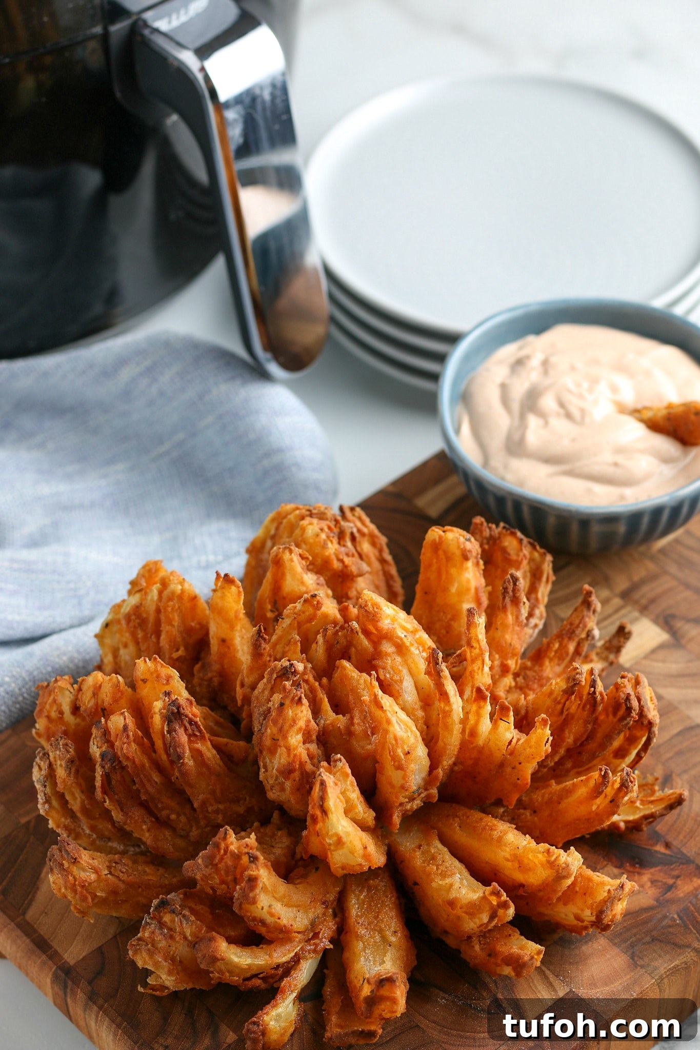 Crispy Air Fryer Bloomin' Onion Recipe for Game Day 12 the finished air fried blooming onion recipe with horseradish sauce in the background.