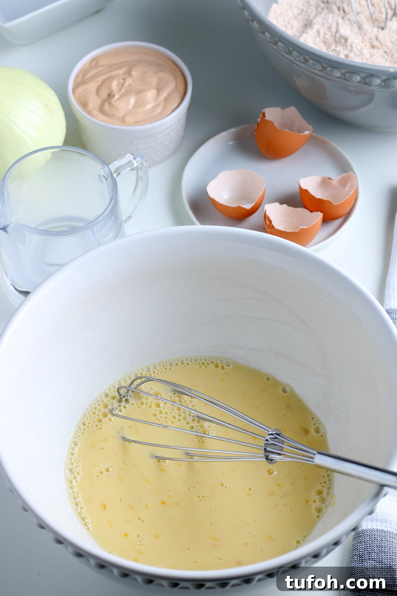 Crispy Air Fryer Bloomin' Onion Recipe for Game Day 9 egg, water, and milk in a large bowl.