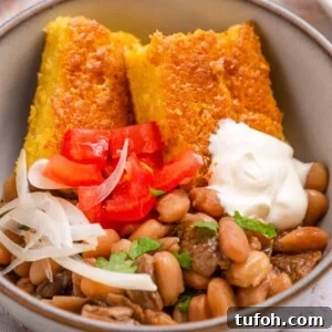 Close up of beans and cornbread in a bowl.