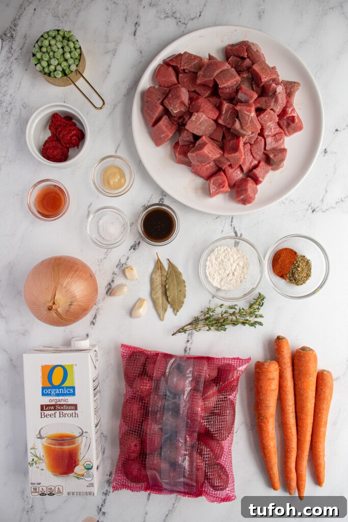 Slow-Cooker Beef Stew with Tender Chunks and Veggies 4 Overhead view of a tabletop filled with the ingredients needed to make slow cooker beef stew.