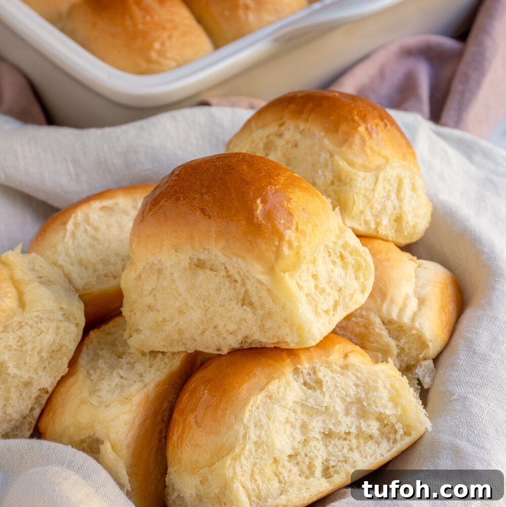 Slow-Cooker Beef Stew with Tender Chunks and Veggies 7 A linen lined basket filled with a bunch of golden brown soft dinner rolls.