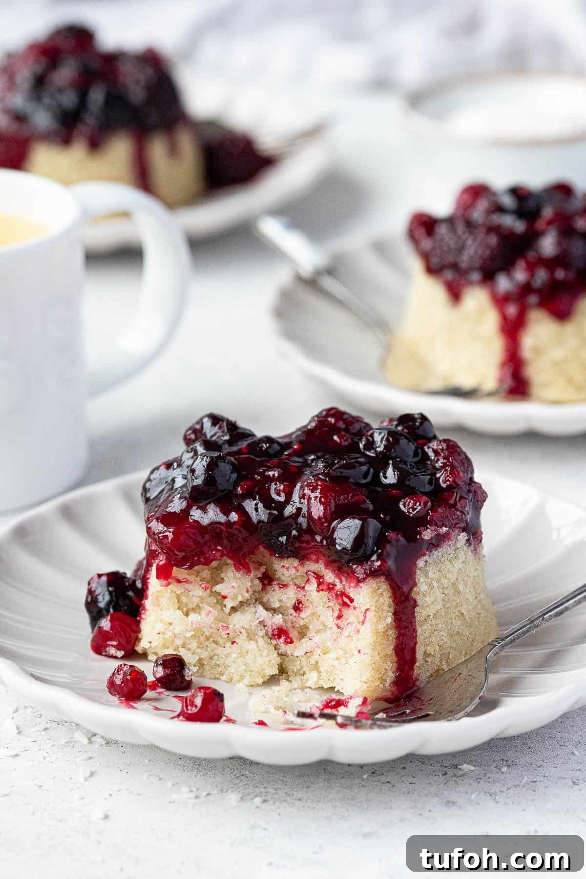 Vegan Berry & Coconut Steamed Puddings Recipe 11 Three steamed puddings, one with a forkful removed.