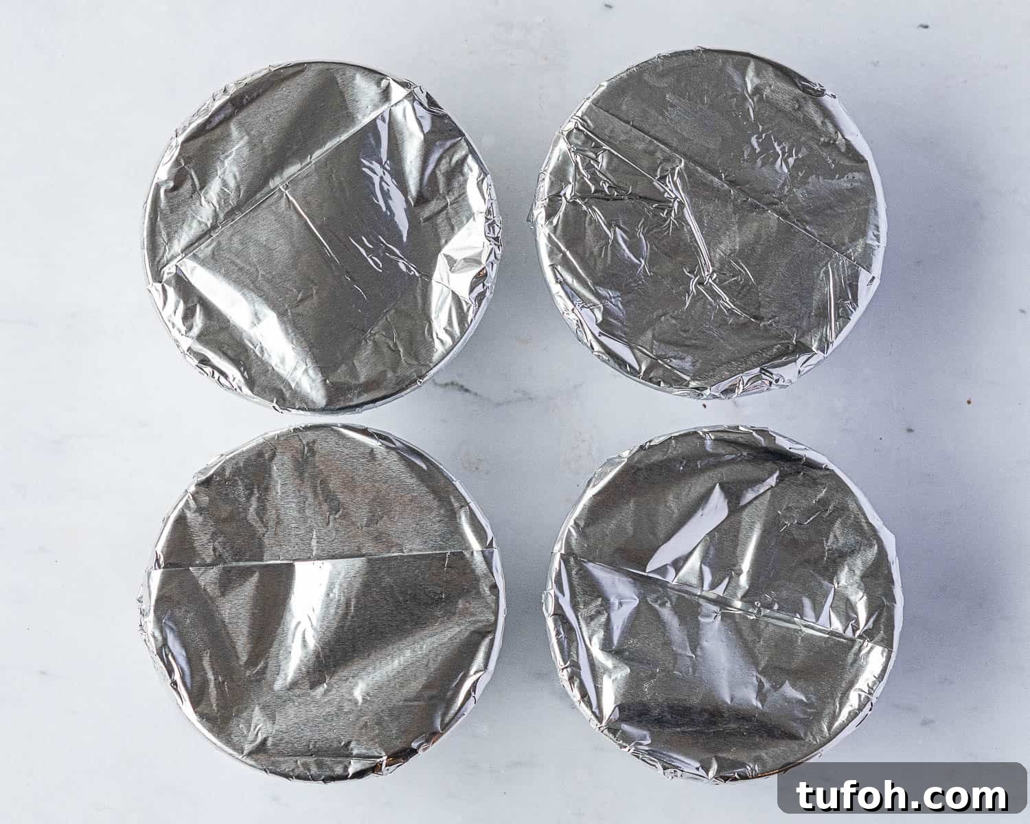 Vegan Berry & Coconut Steamed Puddings Recipe 8 Step 5, the bowls topped with the foil.