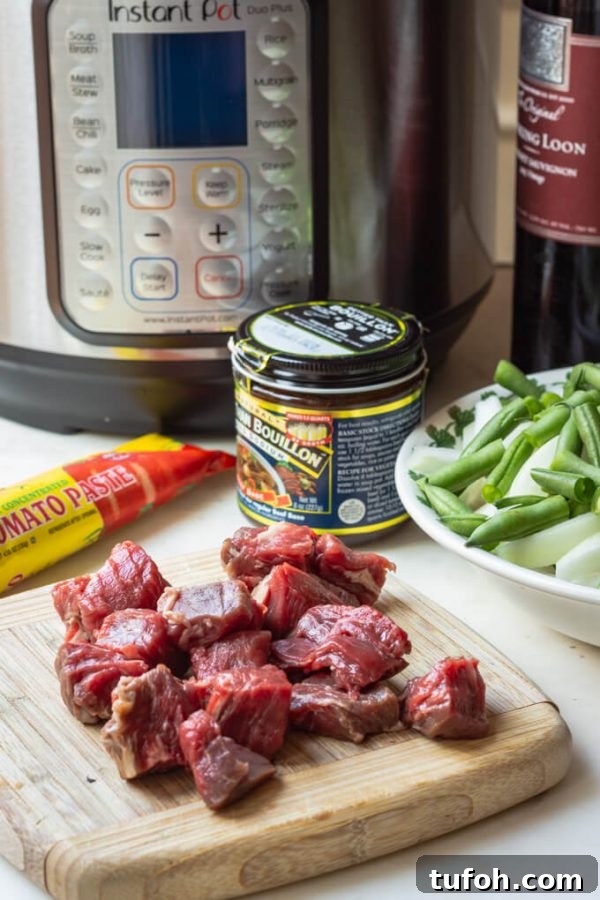 Ingredients for pressure cooker (Instant Pot) vegetable beef soup: cubed beef, tomato paste, beef base, vegetables, and red wine.