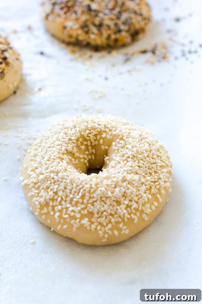 a sesame seed topped bagel before baking