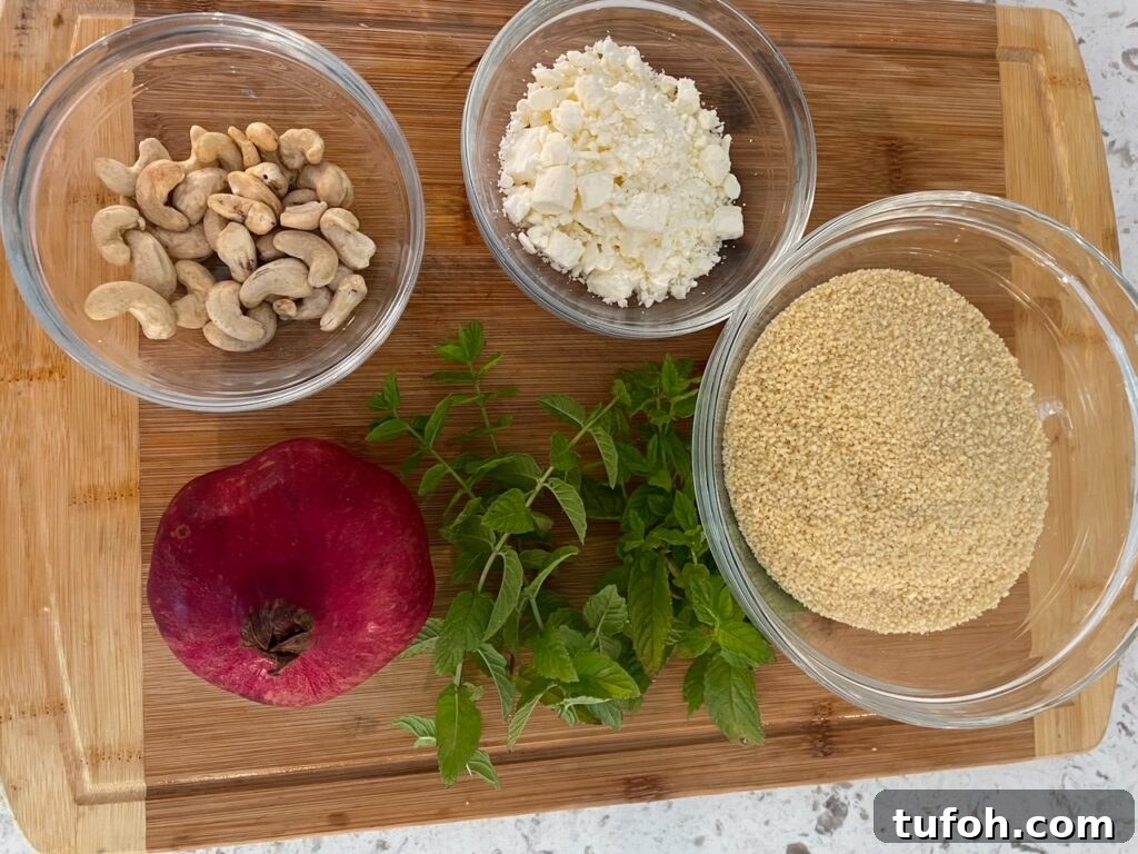 Pomegranate Mint Couscous Salad with Citrus Dressing 4 The ingredients for the Couscous Recipe laid out on a wooden cutting board - almonds, feta, couscous, mint, and pomegranate