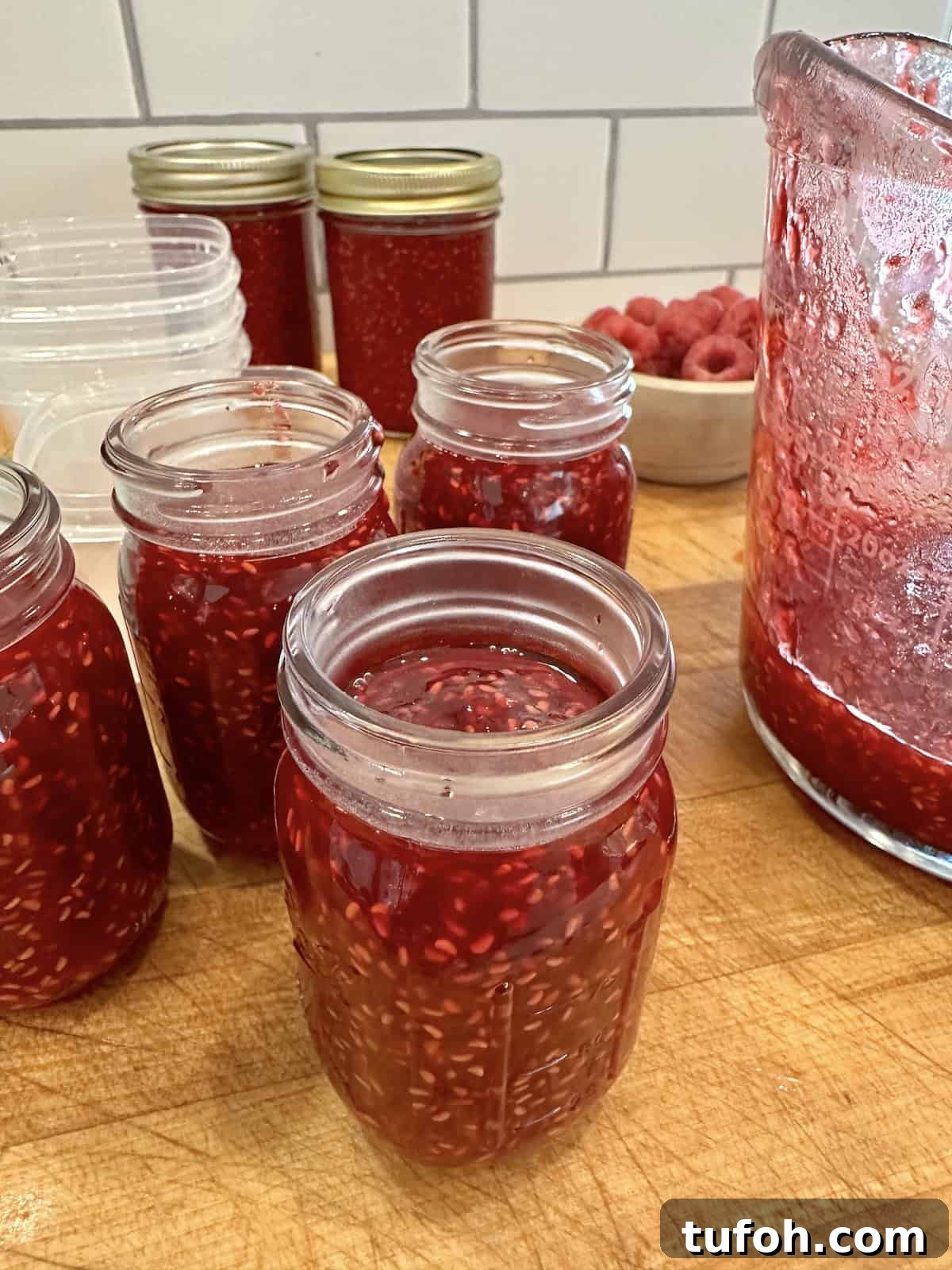 No-Cook Raspberry Jam Without Pectin or Canning 2 Easy small batch raspberry jam in jars on a cutting board.