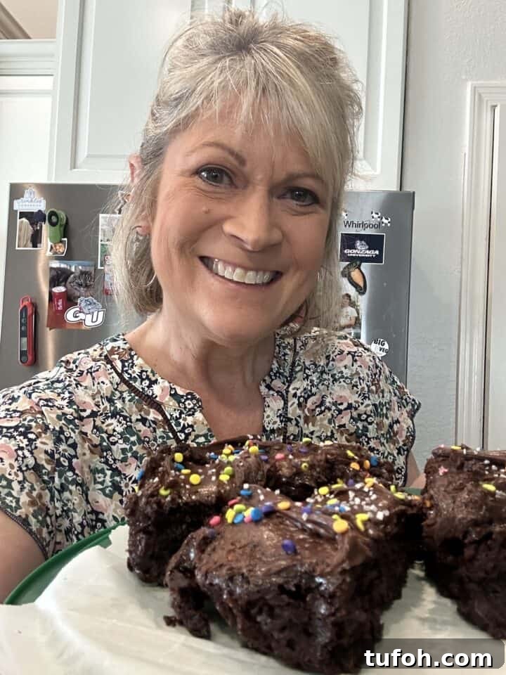 No-Cook Raspberry Jam Without Pectin or Canning 3 Melinda in the kitchen holding a plate of chocolate cake slices.