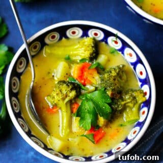 Creamy European Broccoli, Leek & Potato Soup Recipe 16 Picture of Broccoli Leek Potato Soup in a blue bowl with a spoon