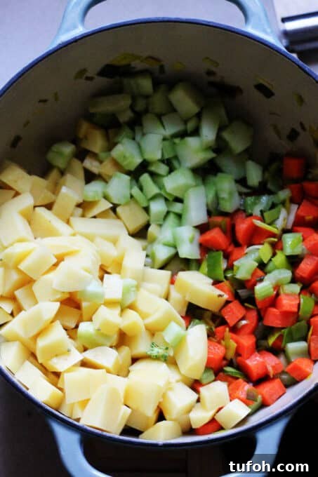 A close up picture of Broccoli Leek Potato Soup in a colorful bowl with spoon