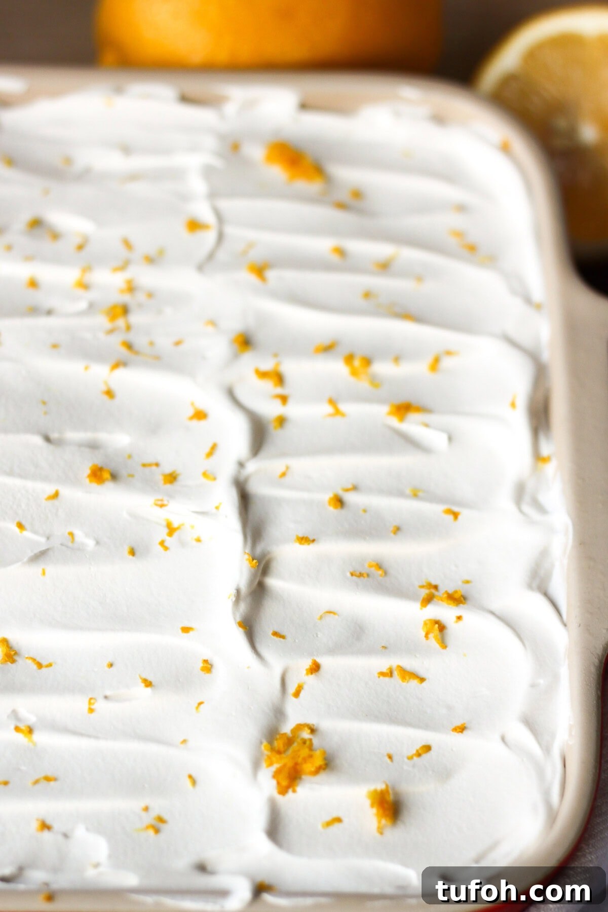 Lemon Lush. It's light and refreshing with 4 layers consisting of bottom pecan crust, lemon cream cheese, lemon pudding and topped with a whipped layer garnished with lemon zest. #lemonlush #lemondessert #lemonlasagna #nobake #onepandesserts #potluckdesserts #creamcheesedesserts #puddingdesserts Pan of Lemon Lush