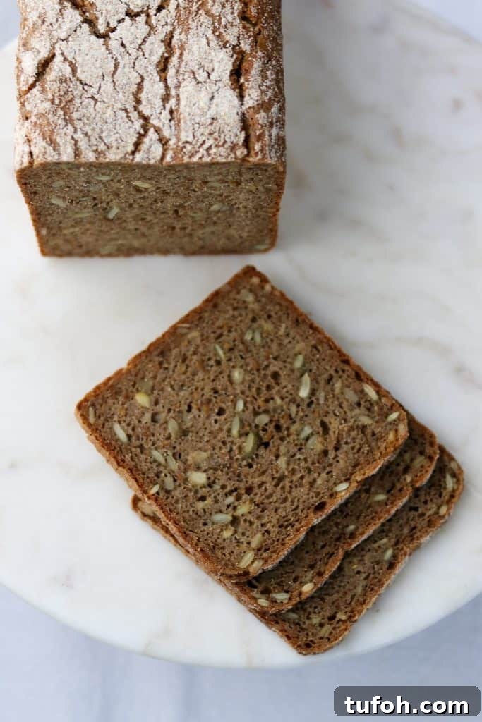 Sourdough Danish Rugbrød Rye Loaf Recipe 4 Three rye bread slices next to a loaf of rye bread on a plate