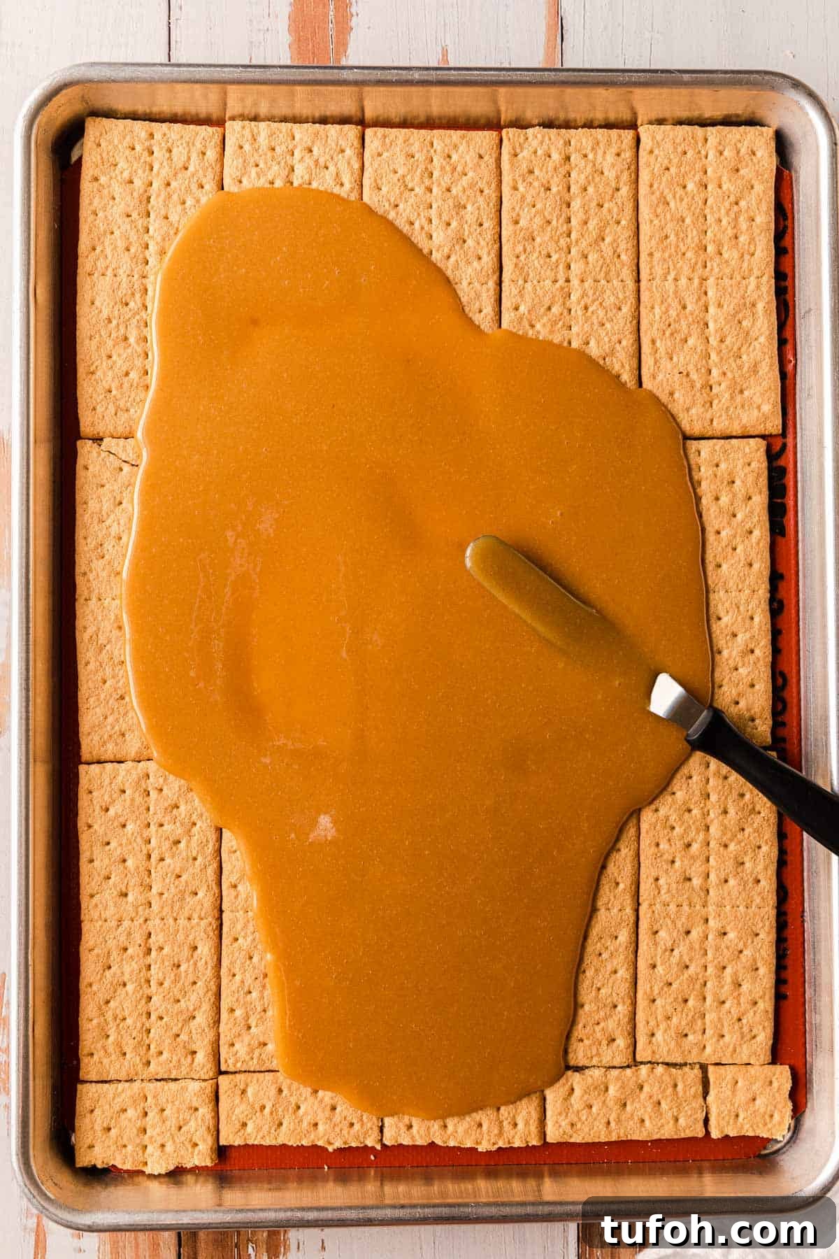 Graham Cracker Praline Recipe — Crunchy Caramel Candy Tutorial 7 Spreading caramel sauce over graham crackers.