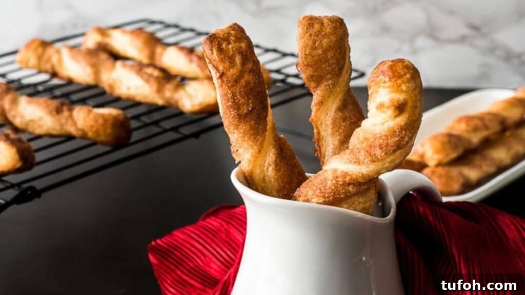21 Kid-Friendly Treats to Make Together (Simple Recipes) 13 Freshly homemade cinnamon twists in a white cup with more on a cooling rack in the background.