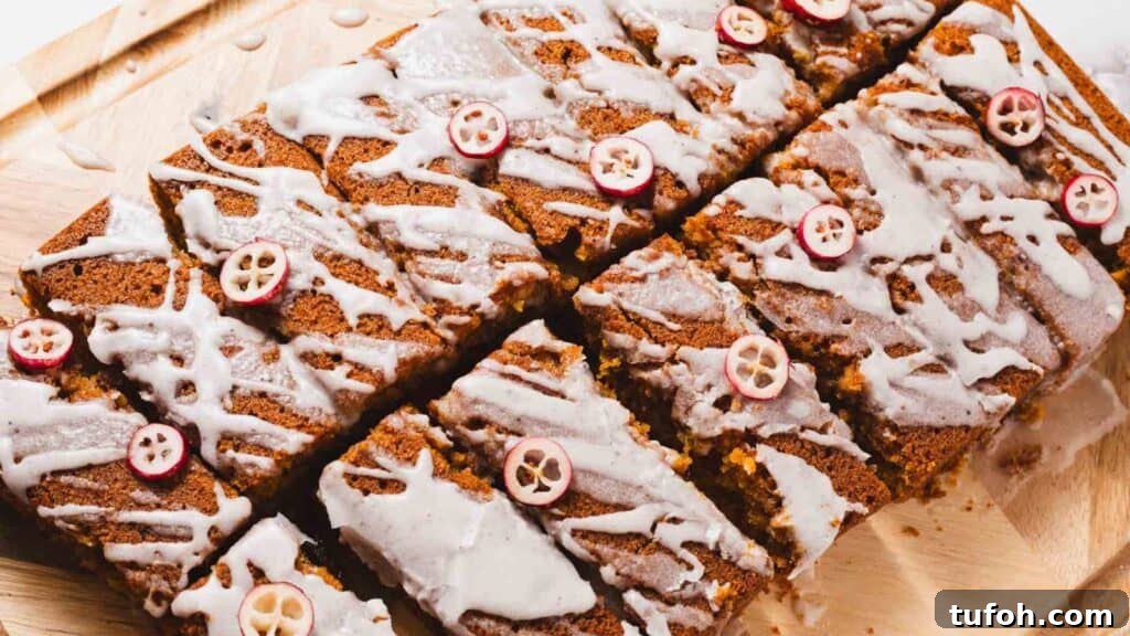 21 Kid-Friendly Treats to Make Together (Simple Recipes) 20 Sliced pumpkin bread topped with white icing and small cranberry slices, arranged on a wooden cutting board.