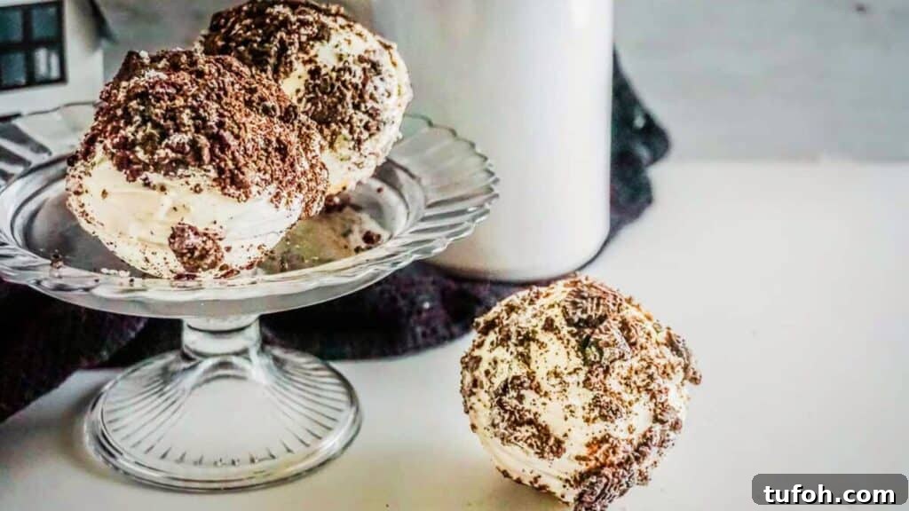 21 Kid-Friendly Treats to Make Together (Simple Recipes) 9 A glass dessert stand holds two cookies and cream hot chocolate bombs.