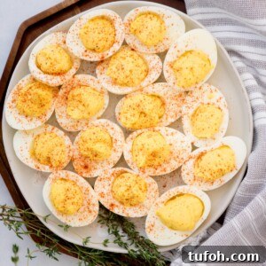Southern-Style Deviled Eggs with Sweet Relish 11 Paprika sprinkled deviled eggs served on a white plate.