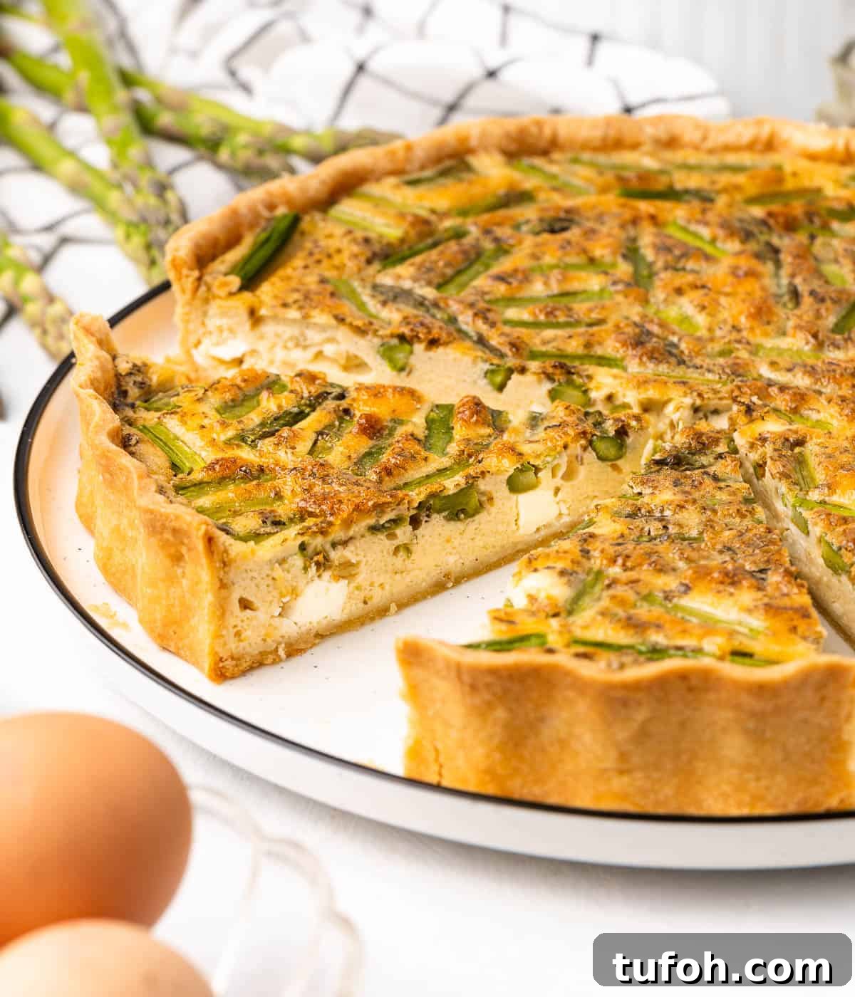 Feta and Asparagus Quiche Recipe for Spring Brunch 8 Close up on two cut out slices of quiche over the serving plate.