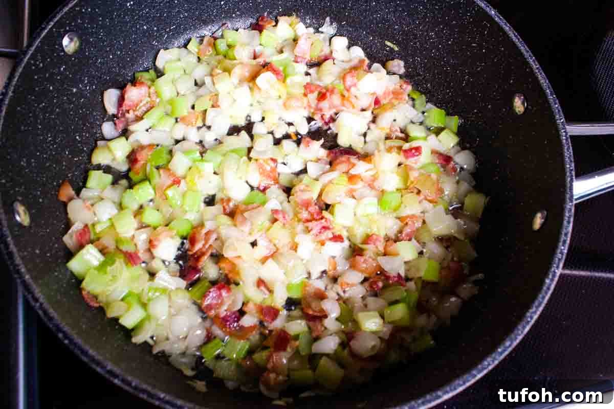 Savory Bacon and Cranberry Stuffing Recipe for Holidays 4 The onion and celery added to a large skillet with bacon.