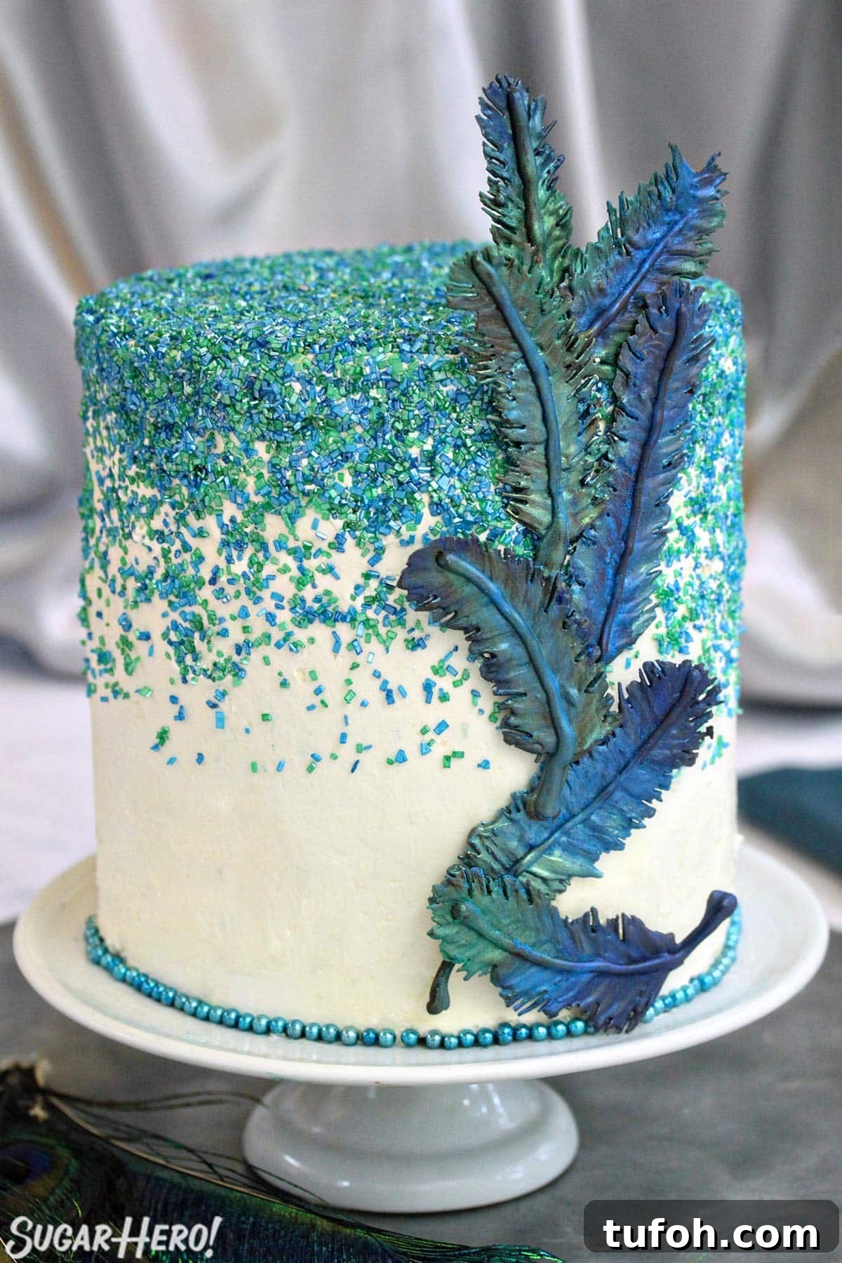 Decadent Chocolate Feather Cookies Recipe 2 Cake with an assortment of blue and green chocolate feathers affixed to the side.