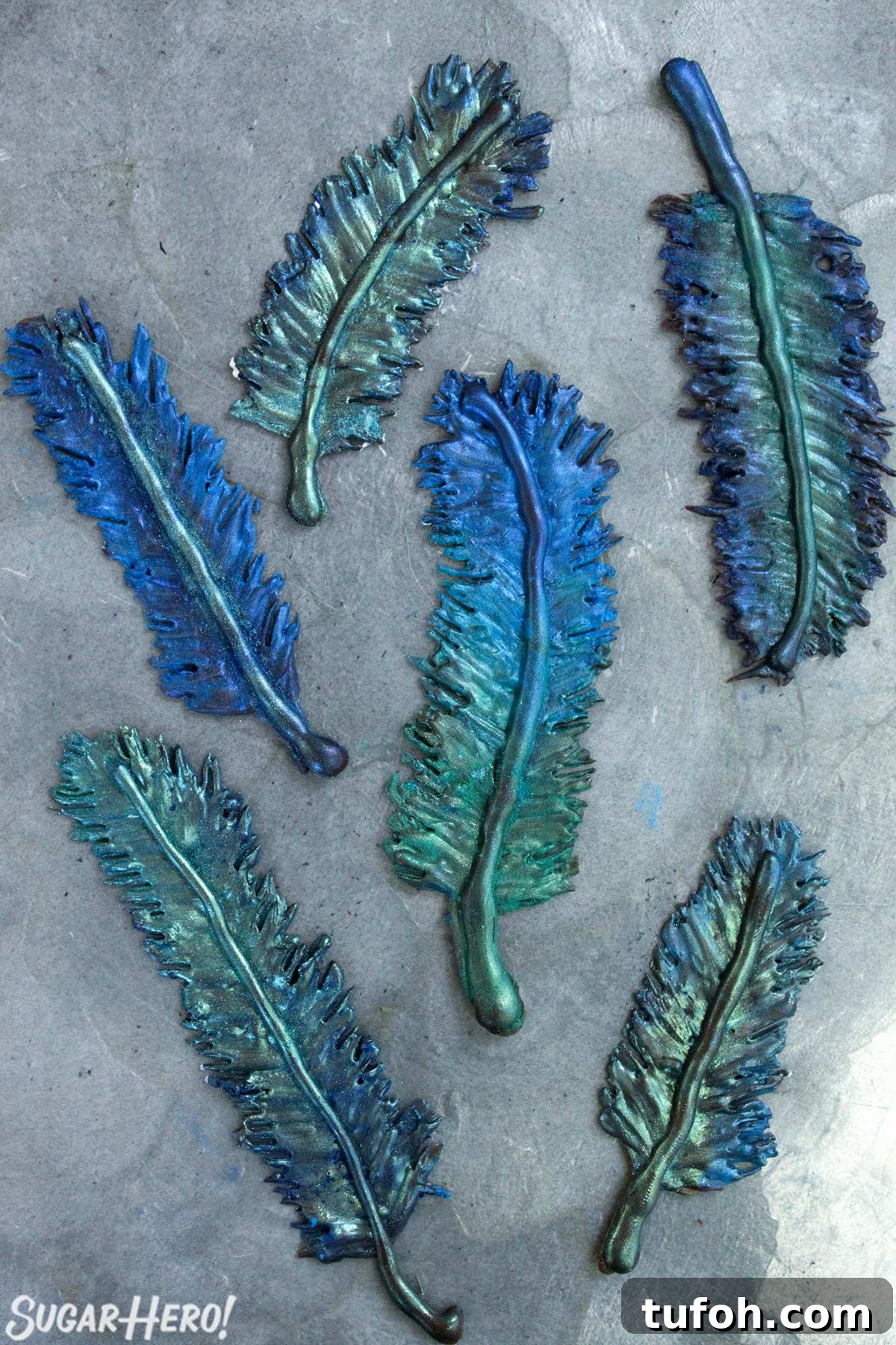 Decadent Chocolate Feather Cookies Recipe 10 Chocolate feathers painted with blue and green luster dust on a silver platter.