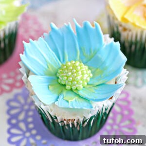 Decadent Chocolate Feather Cookies Recipe 13 Close up of a blue chocolate flower cupcake sitting on a pink and purple doily.