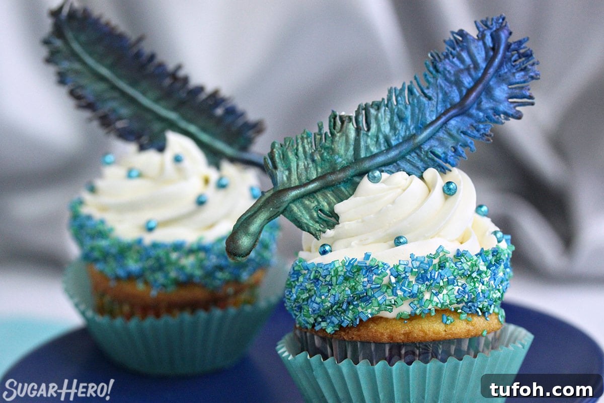 Decadent Chocolate Feather Cookies Recipe 3 Two cupcakes on a blue plate with blue-green chocolate feathers on top.