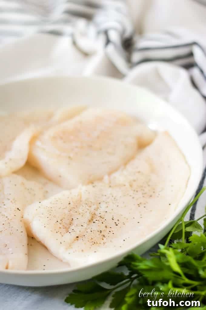 Crispy Beer-Battered Cod Recipe for Perfect Fish Fry 3 The raw fish has been placed on a plate and seasoned.
