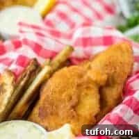 Crispy Beer-Battered Cod Recipe for Perfect Fish Fry 7 Fried fish, in a basket, served with fries and tartar sauce.