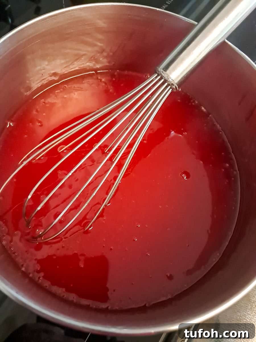 Amish Fruit Jello Cake Recipe: Classic Layered Dessert Guide 7 strawberry sauce cooked in a saucepan.