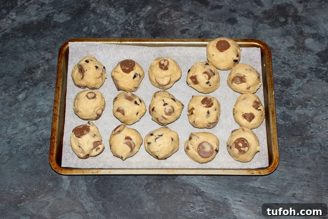 Rolo cookie dough balls on a small lined baking tray