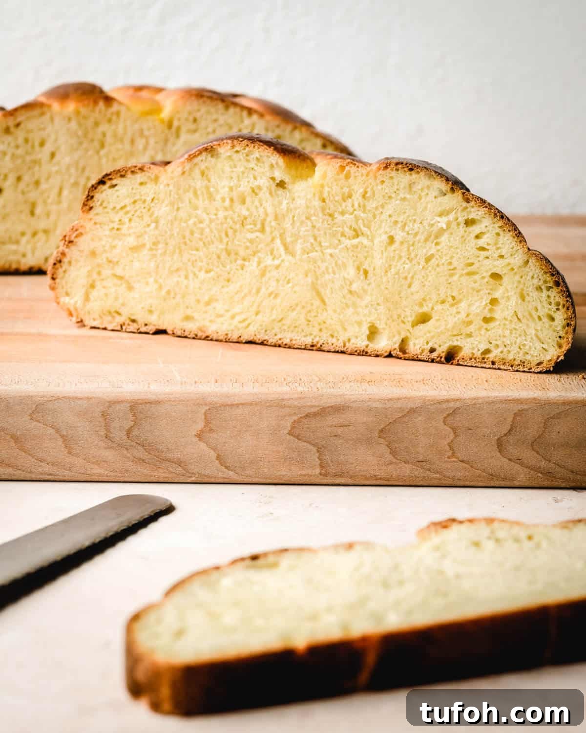 Sourdough Challah Recipe: Step-by-Step Guide for Perfect Braids 2 Challah bread sitting on a cutting board and a piece cut away