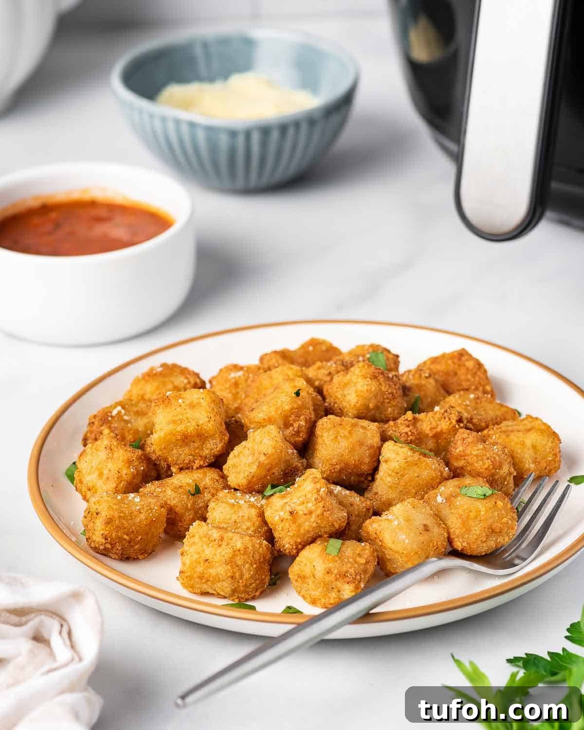 A plate of air fryer cauliflower gnocchi with fresh herbs on top.