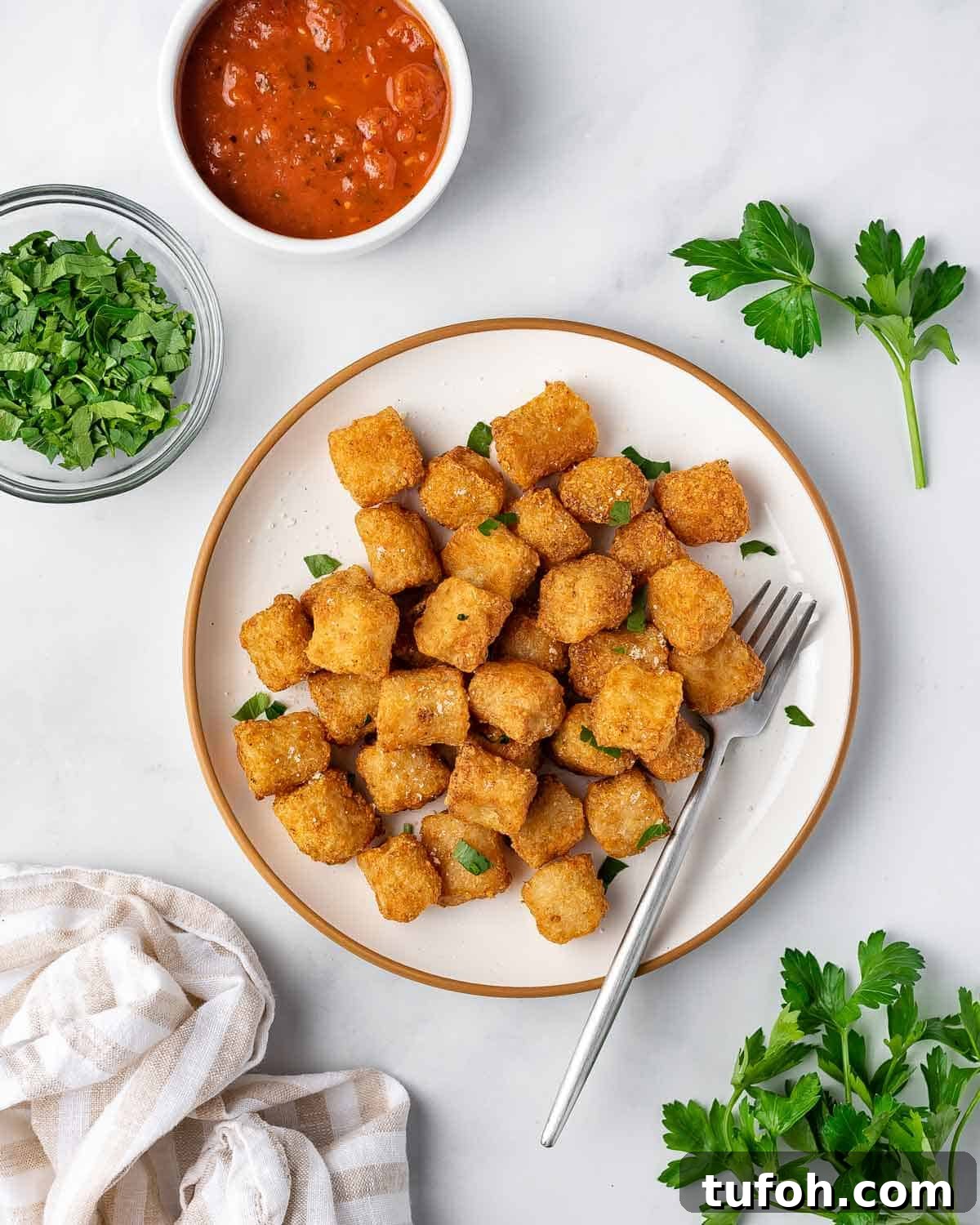 A plate of air fryer cauliflower gnocchi with fresh herbs scattered on top.