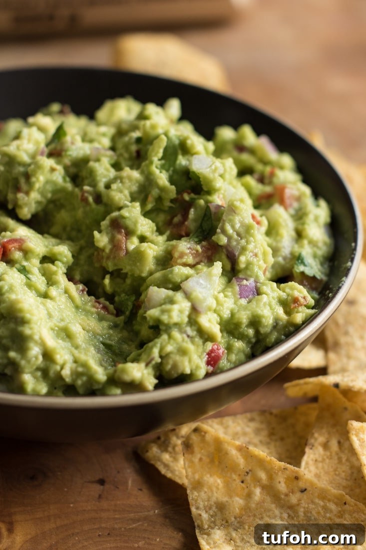 Creamy Vegan Guacamole Recipe for Parties and Snacks 2 Guacamole with tortilla chips arround the bowl.