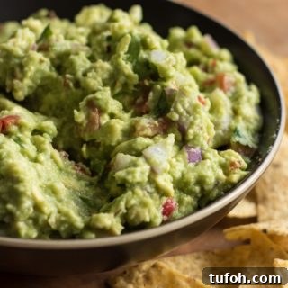 Creamy Vegan Guacamole Recipe for Parties and Snacks 5 Easy guacamole close up, with tortillas arround the bowl.