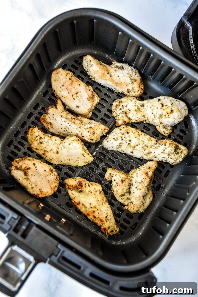 cooked air fryer chicken tenders in the air fryer basket.
