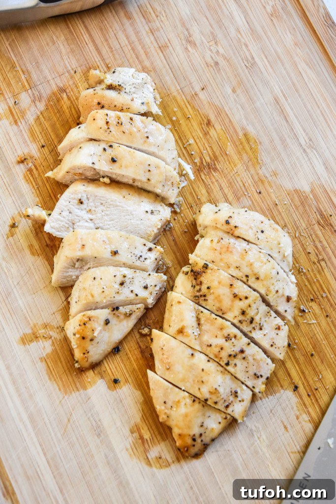 sliced chicken on a cutting board is one way how to cook chicken for meal prep.