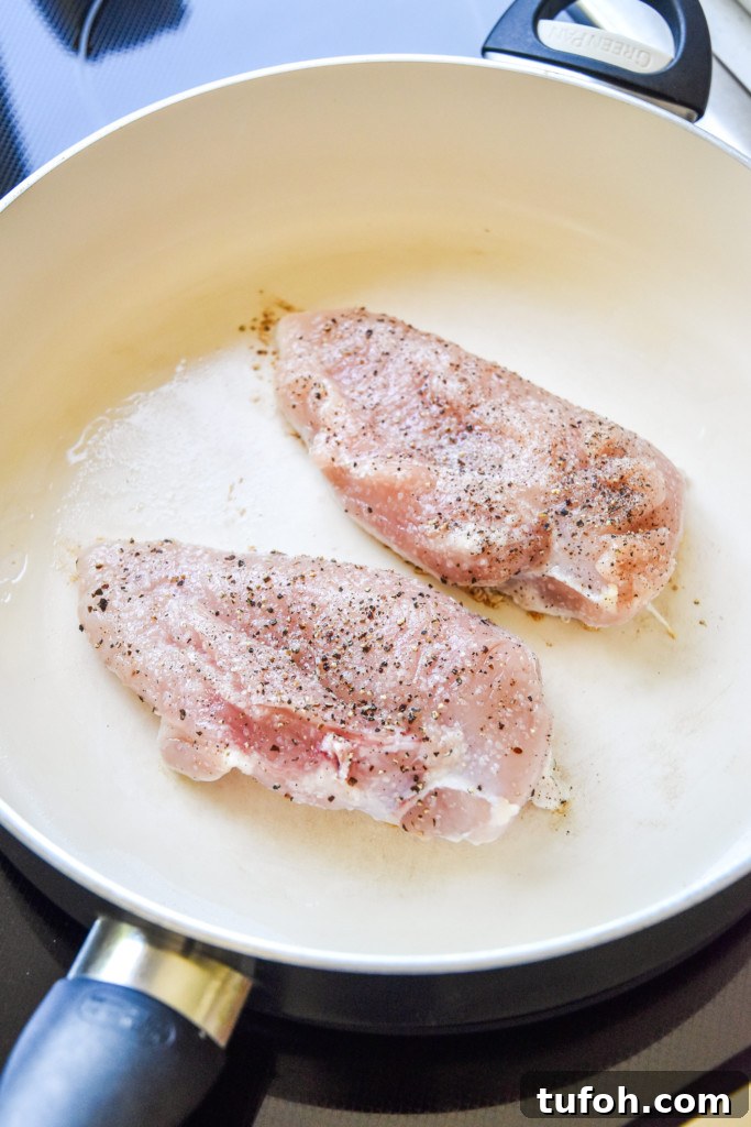 raw chicken in a pan on stovetop.