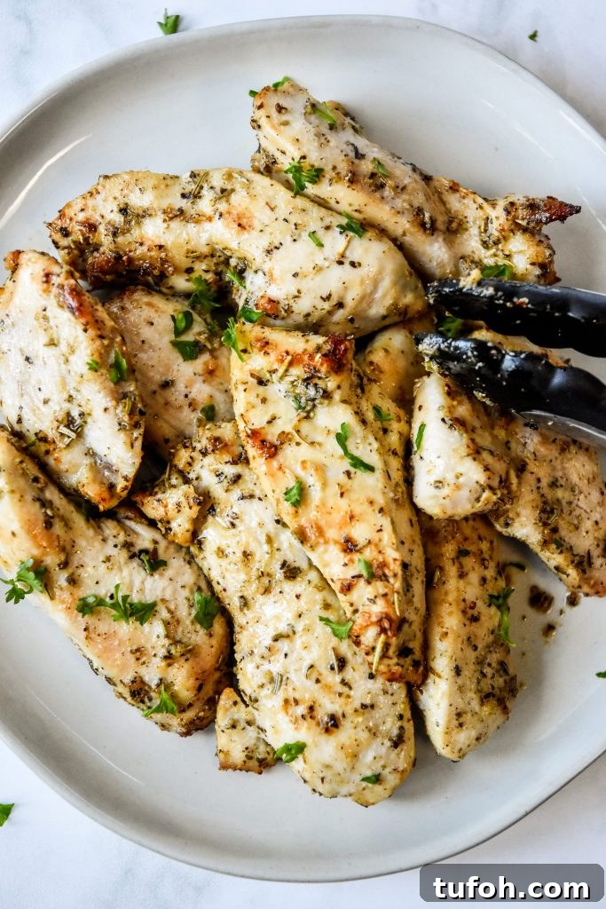 a plate of air fryer chicken tenders with tongs on the side.