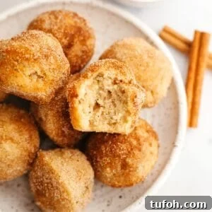 Cinnamon Mini Muffins Recipe: Quick, Soft & Flavorful 15 A small plate full of mini cinnamon muffins, one has a bite taken out of it.